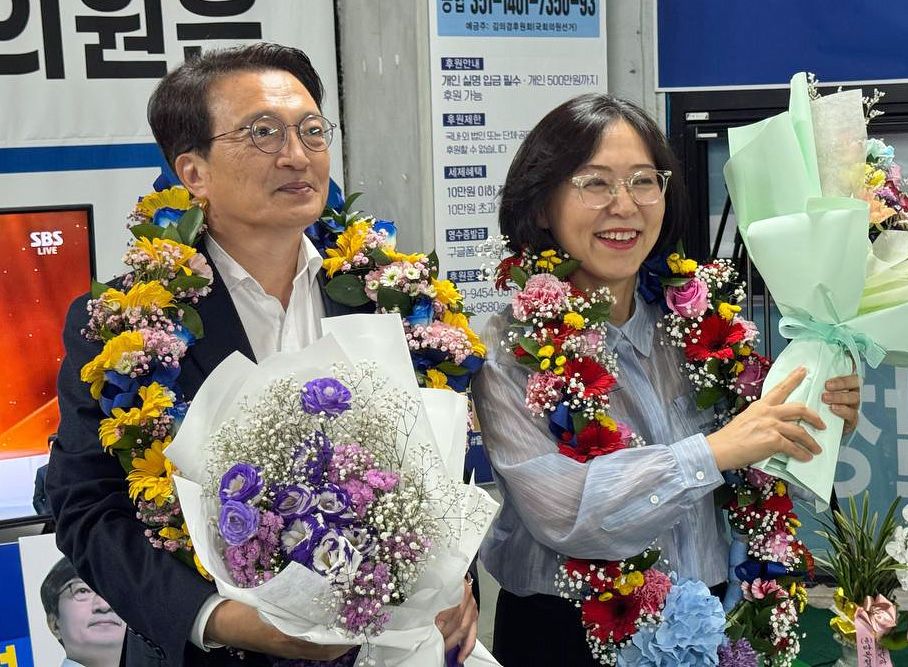 더불어민주당 김의겸(왼쪽) 후보가 3일 전북 군산·김제·부안갑 국회의원 재선거에서 당선이 확실시되자 꽃목걸이를 걸고 부인과 함께 기뻐하고 있다. 연합뉴스