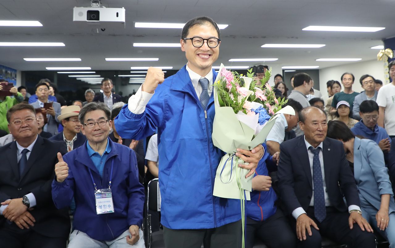 김상욱 더불어민주당 울산시장 후보가 3일 오후 울산 남구에 마련된 자신의 선거캠프에서 당선이 확실시 되자 꽃다발을 들고 환호하고 있다. 뉴스1