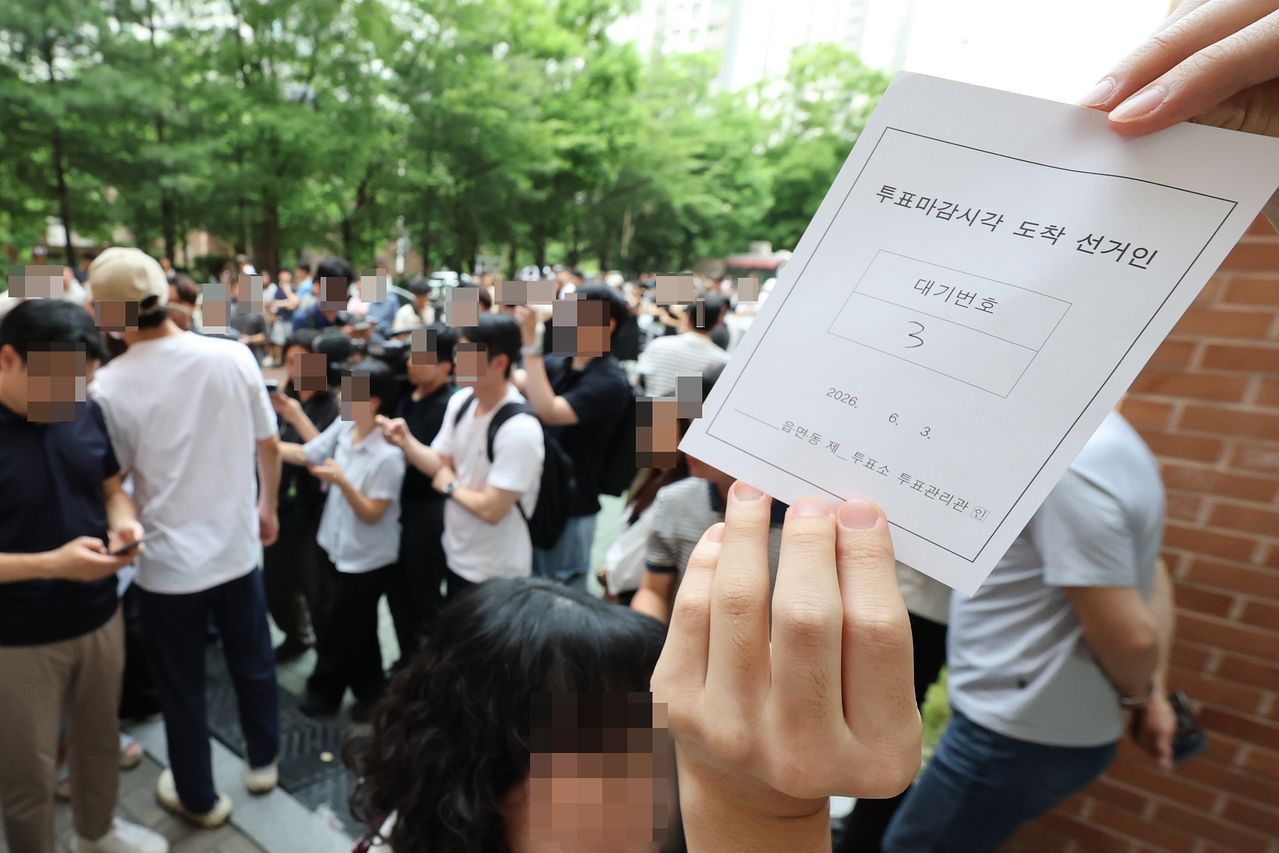 지방선거 본투표일인 3일 서울 송파구 잠실2동6투표소에서 투표용지 부족으로 유권자들이 대기하는 등 혼란이 빚어지고 있다.    한 시민이 투표 마감시간 이후 투표가 순서대로 가능하도록 정한 대기표를 보여주고 있다. 연합뉴스