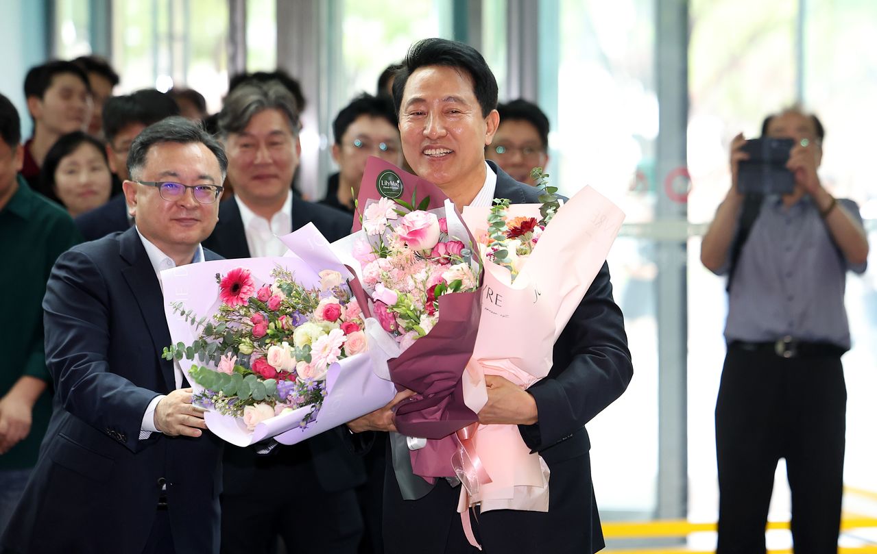 오세훈 서울시장이 4일 서울시청으로 들어서며 직원들에게 받은 꽃다발을 들고 있다. 연합뉴스