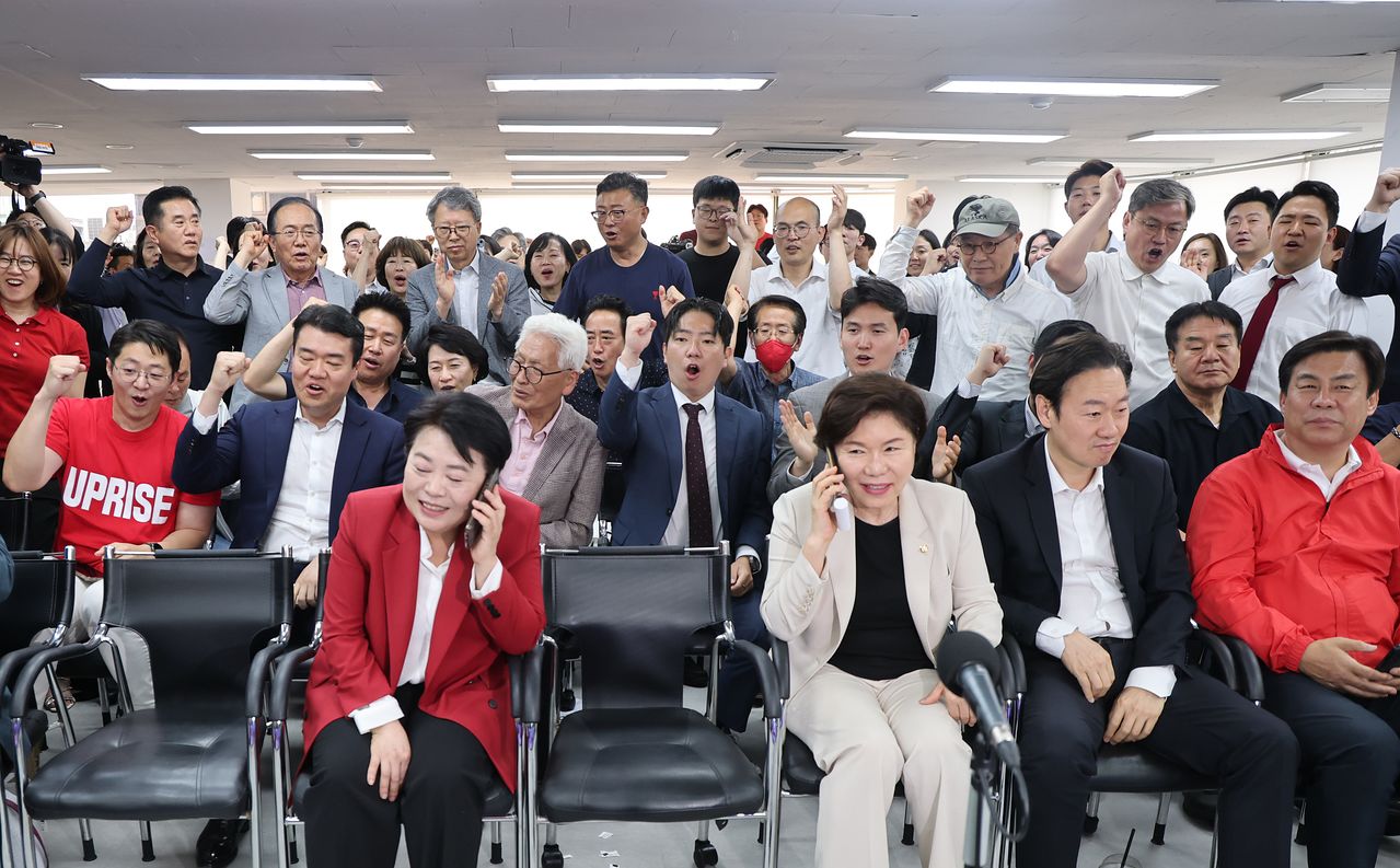 서울 종로구 대왕빌딩에 마련된 국민의힘 오세훈 서울시장 후보 선거사무소에서 선대위 관계자와 오 후보 지지자들이 개표 방송을 시청하며 기뻐하고 있다. [연합뉴스]