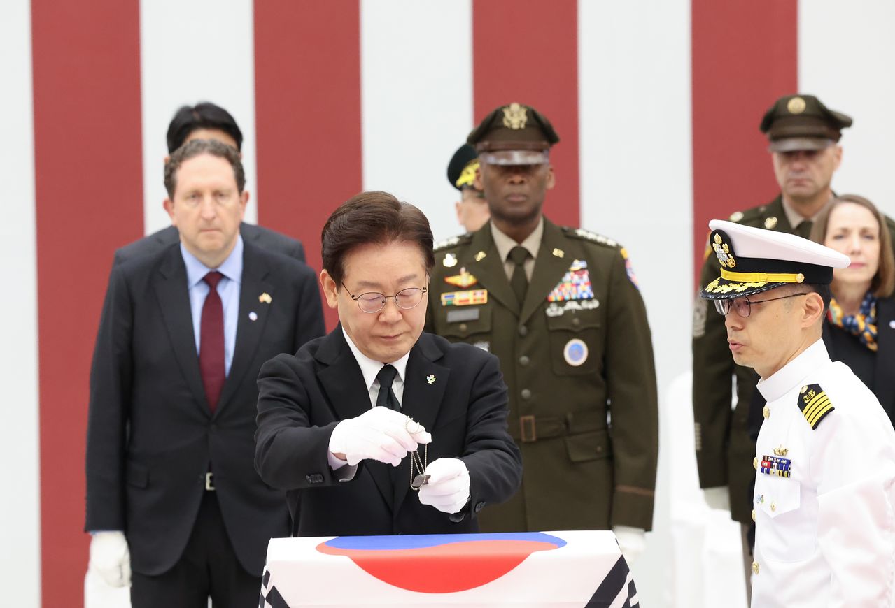 이재명 대통령이 5일 경기 성남 서울공항에서 열린 한·미 6·25전사자 유해 상호 봉환식에서 한국군 대표 유해 1구에 무명 인식표를 수여하고 있다. 청와대사진기자단