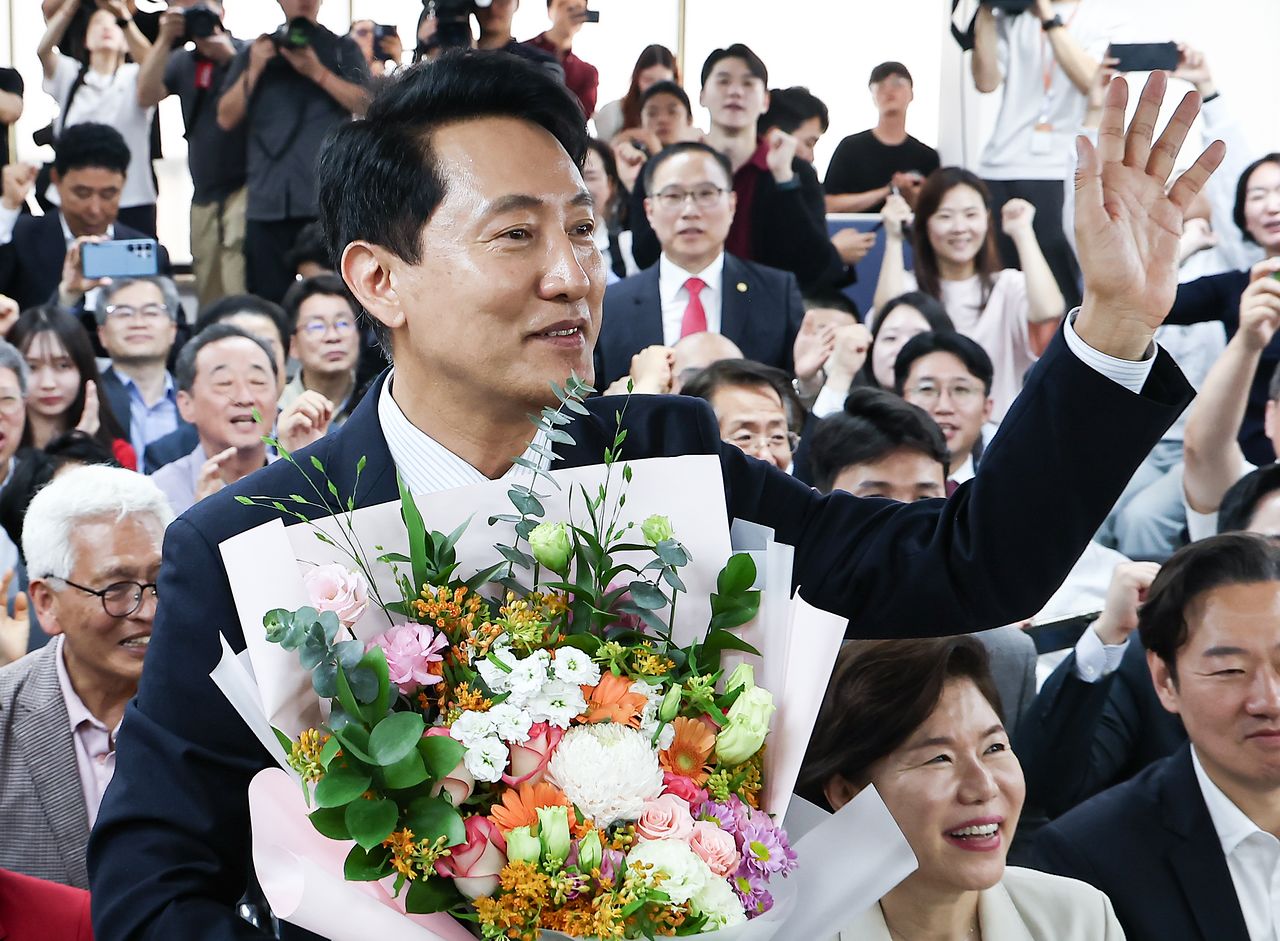 6·3 지방선거에서 당선된 오세훈 국민의힘 서울시장 후보가 4일 서울 종로구 선거사무소에서 꽃다발을 전달 받고 환호 하고 있다. 사진 뉴스1