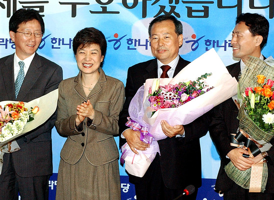2005년 10월 27일 박근혜 당시 한나라당 대표가 유승민(맨 왼쪽) 당시 당선자 등 10·26 재선거에서 승리한 후보들에게 꽃다발을 전달한 뒤 웃고 있다. 왼쪽부터 유 당선자, 박 대표, 정진섭·임해규 당선자. 중앙포토