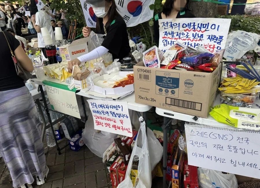 6일 투표용지 부족 사태를 규탄하며 재선거를 요구하는 잠실 개표소 봉쇄 시위가 열리고 있는 서울 송파구 올림픽공원 핸드볼경기장 일대에 지원 용품들이 쌓여있다. 소셜미디어 캡처