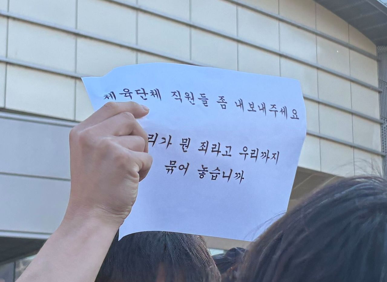 5일 오후 서울 송파구 지방선거 개표소(올림픽공원 핸드볼경기장)에서 부정선거 의혹 제기 시위대가 퇴근 길을 막자 체육 종목단체의 한 직원이 인쇄물을 보이며 막지 말라는 의사를 표시하고 있다. 김예정 기자