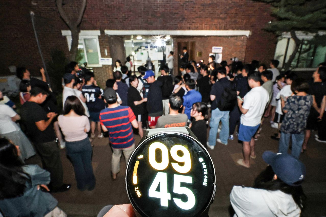 지난 3일 투표용지 부족 사태가 빚어져 밤 10시까지 연장해서 투표가 진행된 서울 송파구 잠실7동 제2투표소 앞에 시민들이 모여 있다. 연합뉴스