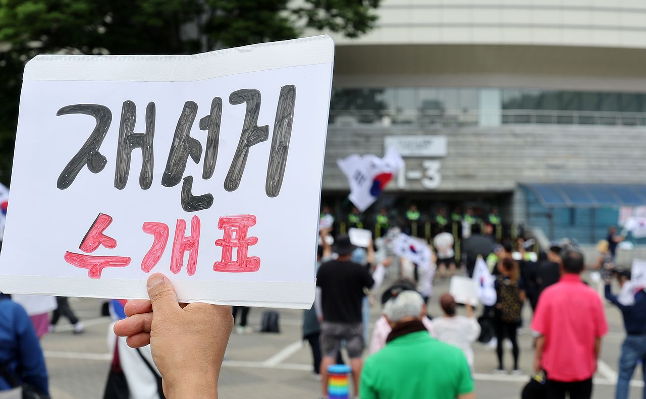제9회 전국동시지방선거 투표용지 부족 사태에 반발한 시민들이 8일 서울 송파구 올림픽공원 핸드볼경기장 개표소 앞에 모여 재선거를 요구하는 구호를 외치고 있다. 뉴스1