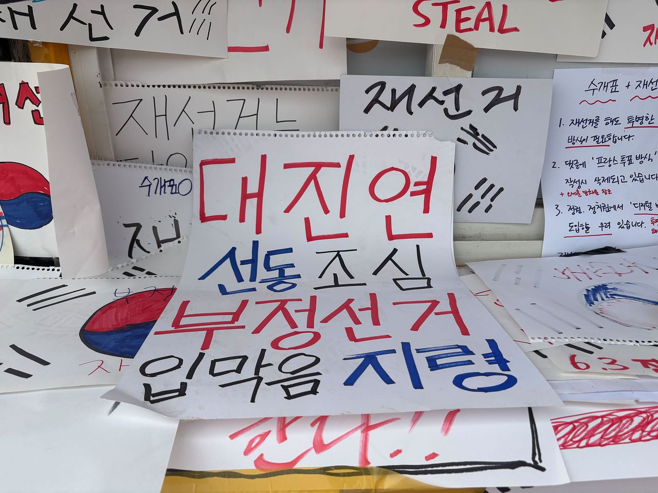 8일 오전 서울 송파구 올림픽공원 개표소 시위 현장에 부정선거를 주장하는 팻말이 붙어 있다. 김예정 기자 