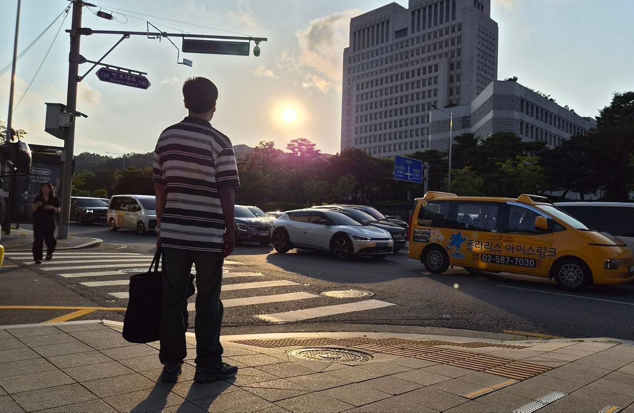 응시제한자가 된 장동재(44)씨가 지난달 28일 서울 서초역사거리에서 대법원을 바라보고 있다. 학창시절 공직을 희망했던 장씨는 법에 관심을 가지고 학부 때 공대에서 법대로 전과했다. 최서인 기자