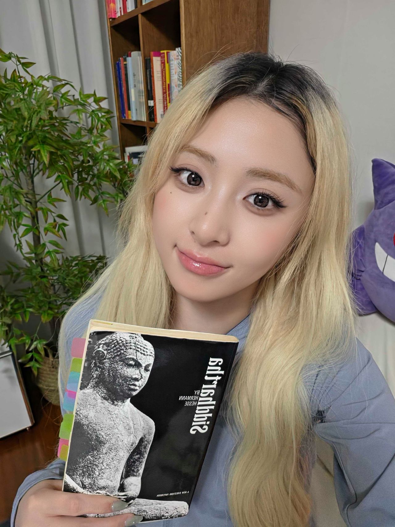 르세라핌 멤버 허윤진. ‘젠지(GenZ)의 책장’ 연재에 참여하는 인터뷰이들에게 지금 읽고 있는 책과 함께하는 자신의 모습을 셀피로 담아달라고 부탁했다. ‘붐팔라’ 활동 중이던 지난달 말 사진을 보낸 허윤진은 인덱스를 여러 군데 붙인 영문판 『싯다르타』를 들고 있었다. [사진 쏘스뮤직]