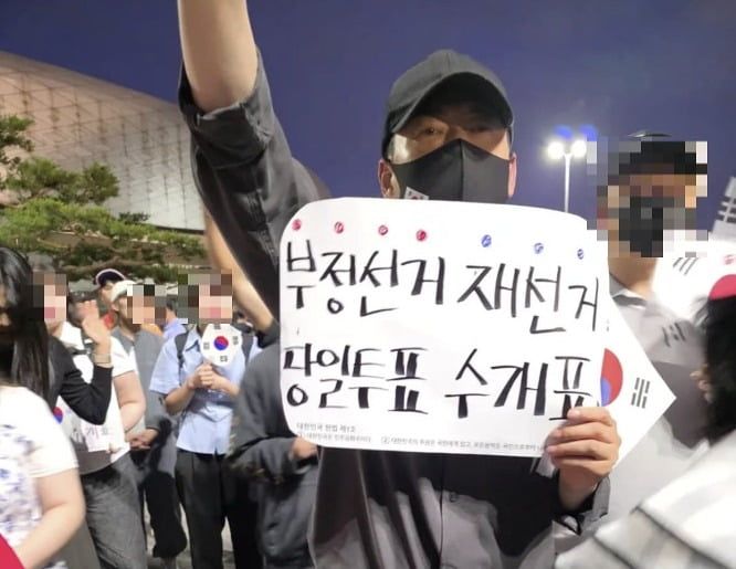 마스크와 모자를 쓴 장동혁 국민의힘 대표가 지난 9일 서울 올림픽공원 핸드볼경기장 앞 집회장에서 구호를 외치고 있다. [사진 인터넷 캡처]