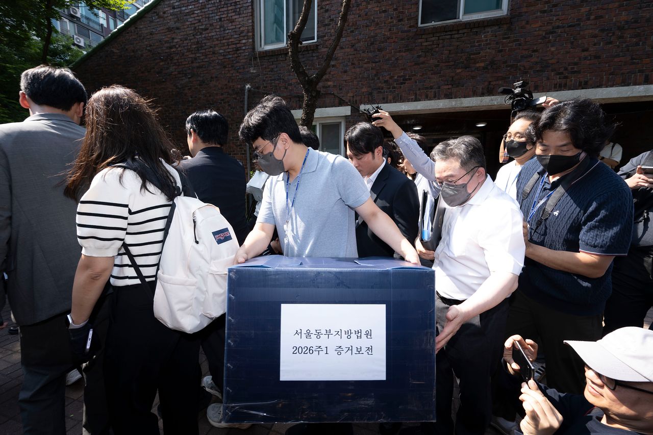 김지연 서울동부지방법원 부장판사와 관계자들이 10일 오후 6·3 지방선거 투표용지 부족 사태가 발생한 잠실7동 제2투표소였던 서울 송파구 우성아파트 노인정의 현장 검증을 마친 뒤 증거물을 들고 현장을 나서고 있다. 장진영 기자