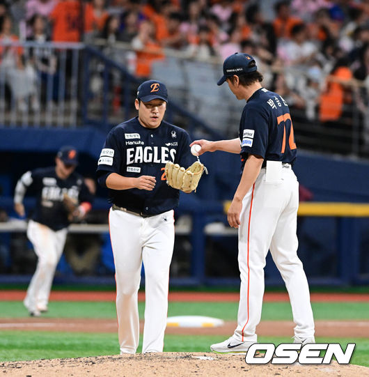 [OSEN=고척, 지형준 기자] 12일 오후 서울 고척스카이돔에서 2026 신한 SOL KBO리그 키움 히어로즈와 한화 이글스의 경기가 열렸다.2연패에 빠진 키움은 안우진, 3연승으로 4위 사수를 노리는 한화는 윌켈 에르난데스를 선발로 내세웠다.9회말 한화 박승민 코치가 이민우에게 볼을 건네고 있다. 2026.06.12/ jpnews@osen.co.kr
