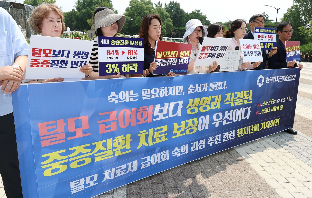 한국환자단체연합회 관계자들이 29일 서울 종로구 청와대 분수대 앞에서 기자회견을 열고 ″탈모 급여화보다 생명과 직결된 중증질환 치료보장이 우선이다″라며 정부의 탈모치료제 급여화 사회적 숙의 과정 추진에 대한 입장을 밝히고 있다. 연합뉴스