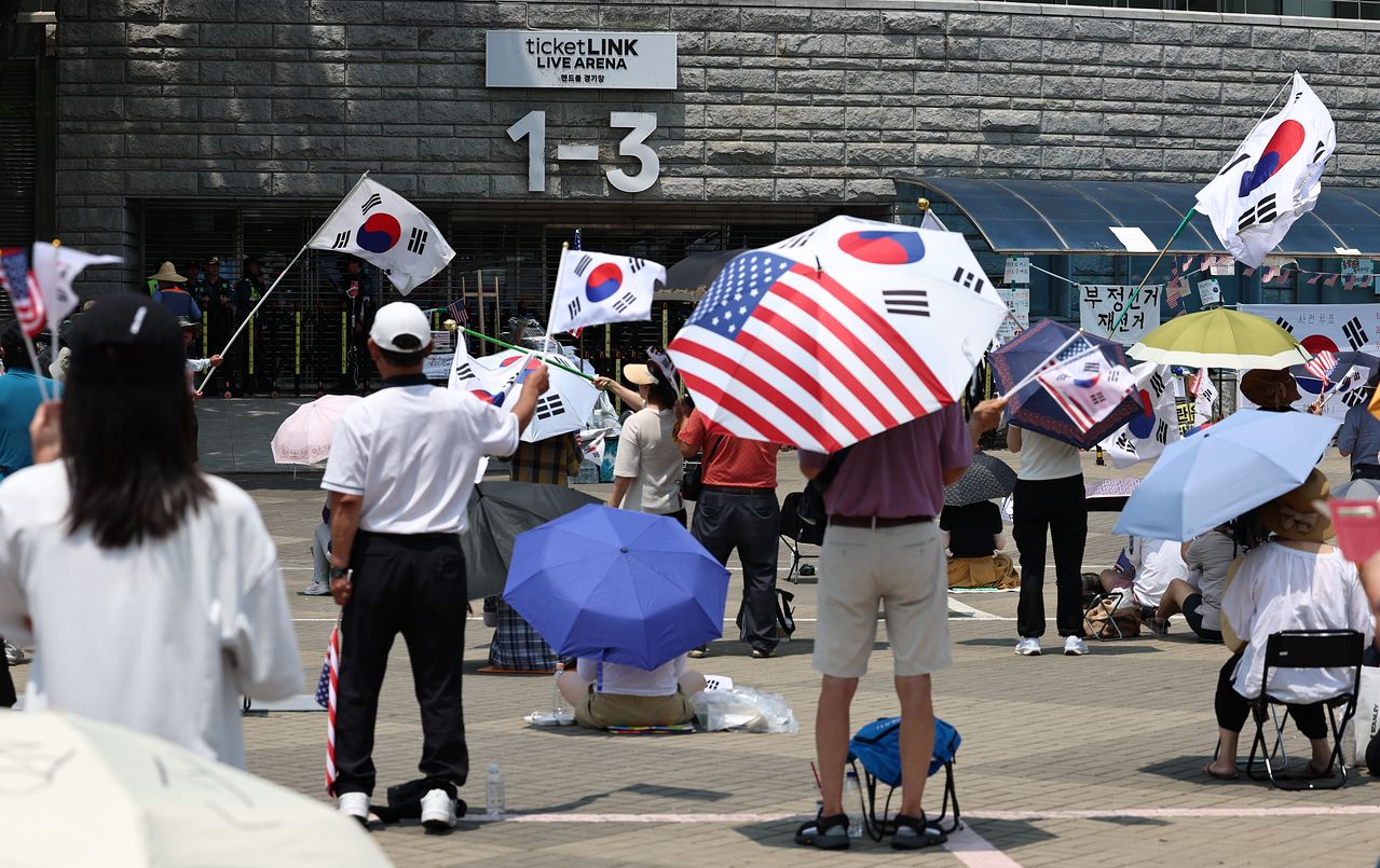 25일 서울 송파구 올림픽공원 핸드볼경기장 인근에서 시위 참가자들이 재선거를 요구하는 구호를 외치고 있다. 뉴스1