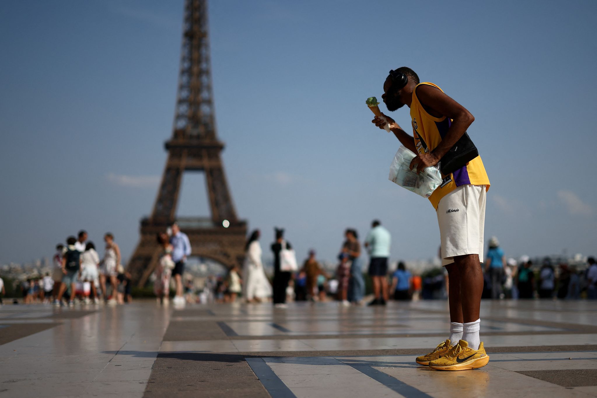 지난 27일(현지시간) 프랑스 파리에서 폭염이 이어지는 가운데 한 시민이 에펠탑 앞에서 아이스크림을 먹으며 더위를 식히고 있다. 로이터=연합뉴스