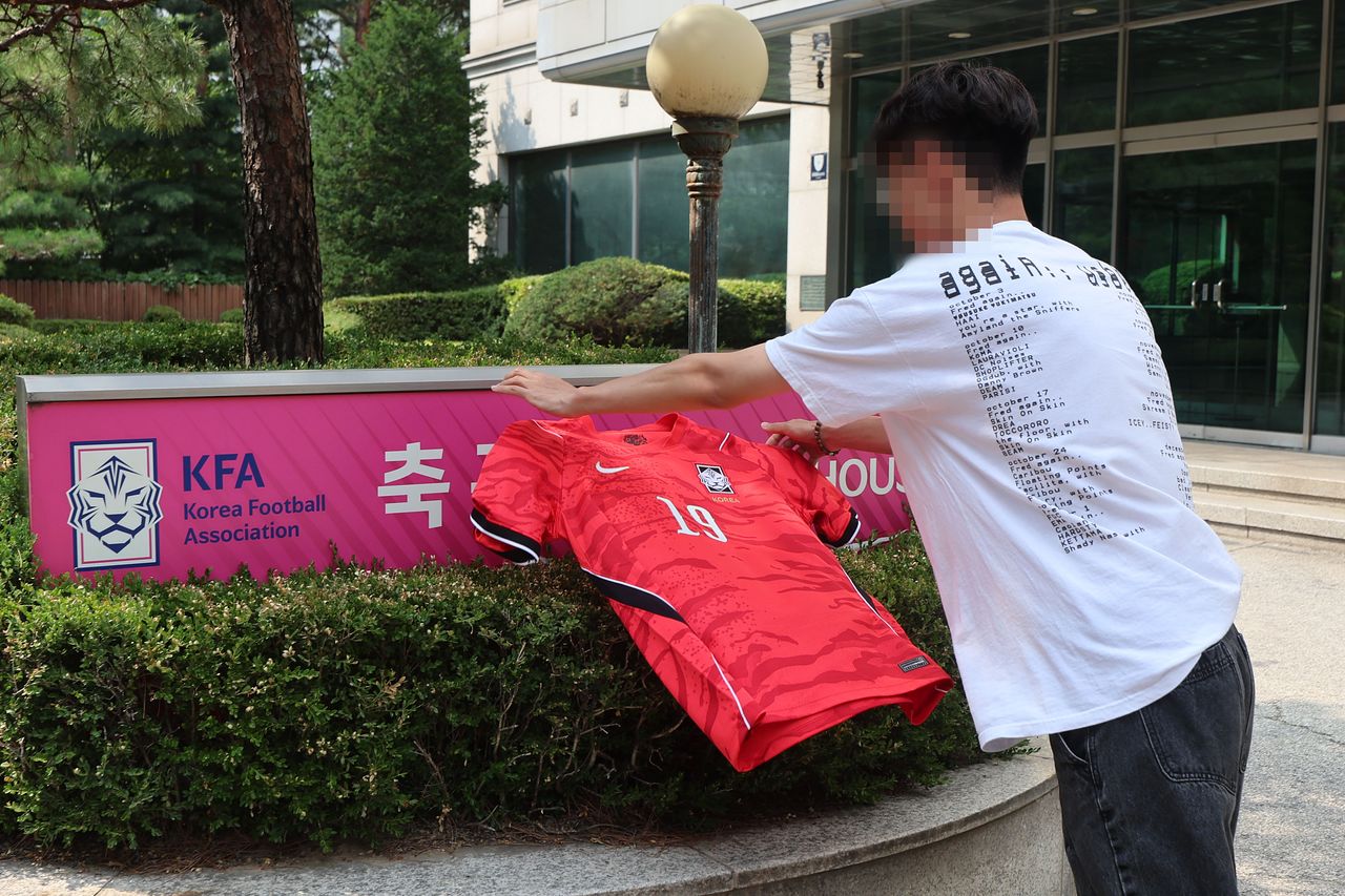 홍명보 감독이 이끌고 있는 한국축구대표팀이 2026 국제축구연맹(FIFA) 북중미 월드컵 조별리그 32강 토너먼트에 떨어졌다. 감독 선임 과정부터 대표팀 운영, 리더십 등 한국 축구를 둘러싼 여러 문제가 한꺼번에 드러난 결과라는 평을 들으며 홍명보 감독 뿐 아니라 대한축구협회도 비난을 피하기 어렵게 됐다.  28일 서울 종로구 축구회관 앞에서 한 축구팬 틱톡커가 한국 국가대표팀 유니폼을 벗어던지고 있다. 뉴시스