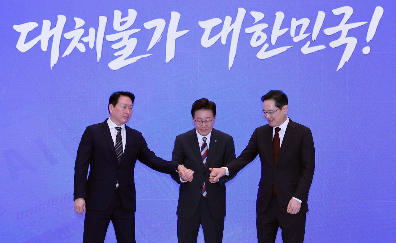 이재명 대통령이 29일 청와대에서 열린 ‘대한민국 대도약 3대 메가프로젝트 국민보고회’에서 최태원 에스케이(SK)그룹 회장과 이재용 삼성전자 회장과 손을 맞잡고 있다. 청와대사진기자단