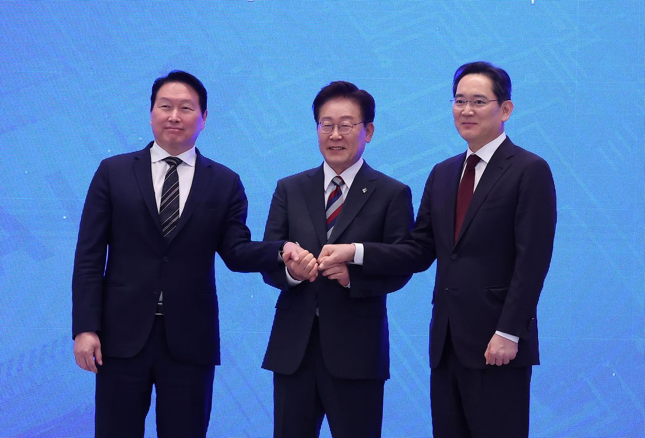 이재명 대통령과 최태원 에스케이(SK)그룹 회장, 이재용 삼성전자 회장이 29일 청와대에서 열린 ‘대한민국 대도약 3대 메가프로젝트 국민보고회’에서 손을 맞잡고 있다. 청와대사진기자단