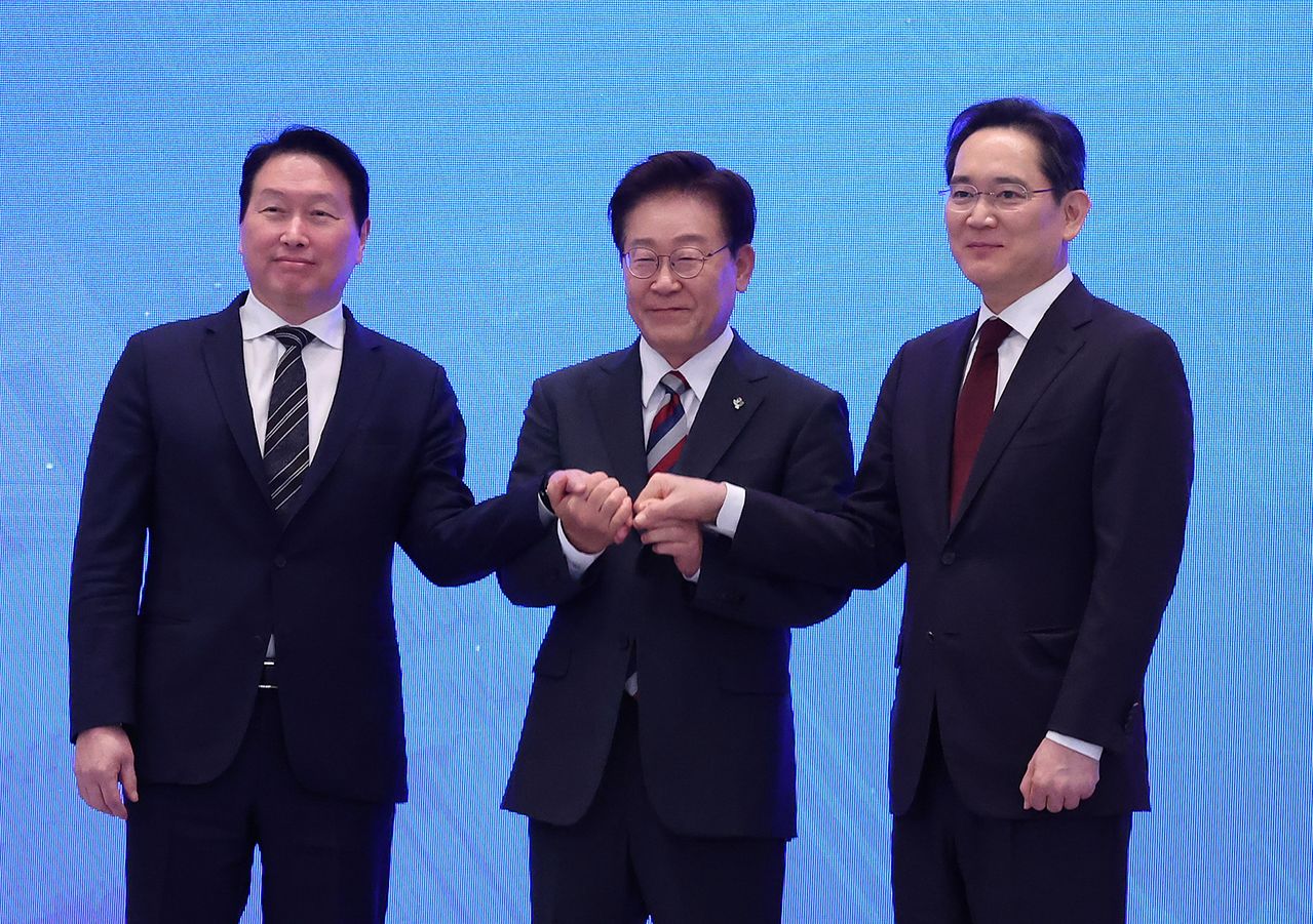 이재명 대통령과 이재용 삼성전자 회장, 최태원 에스케이(SK)그룹 회장이 29일 청와대에서 열린 ‘대한민국 대도약 3대 메가프로젝트 국민보고회’에서 손을 맞잡고 있다. 청와대사진기자단