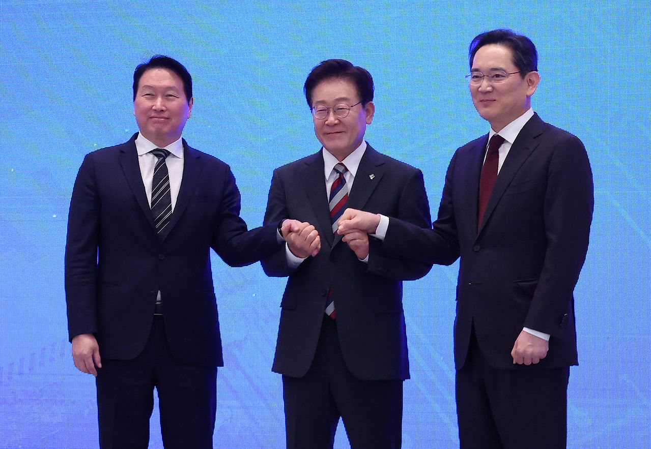 이재명 대통령과 이재용 삼성전자 회장, 최태원 에스케이(SK)그룹 회장이 29일 청와대에서 열린 ‘대한민국 대도약 3대 메가프로젝트 국민보고회’에서 손을 맞잡고 있다. 청와대사진기자단