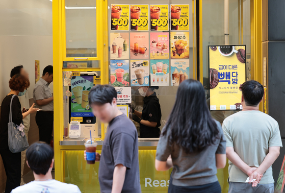 지난해 6월 10일 서울 시내의 한 빽다방 매장 앞에 할인 안내문이 붙어있다. 기사와 직접적인 관련 없음. 연합뉴스