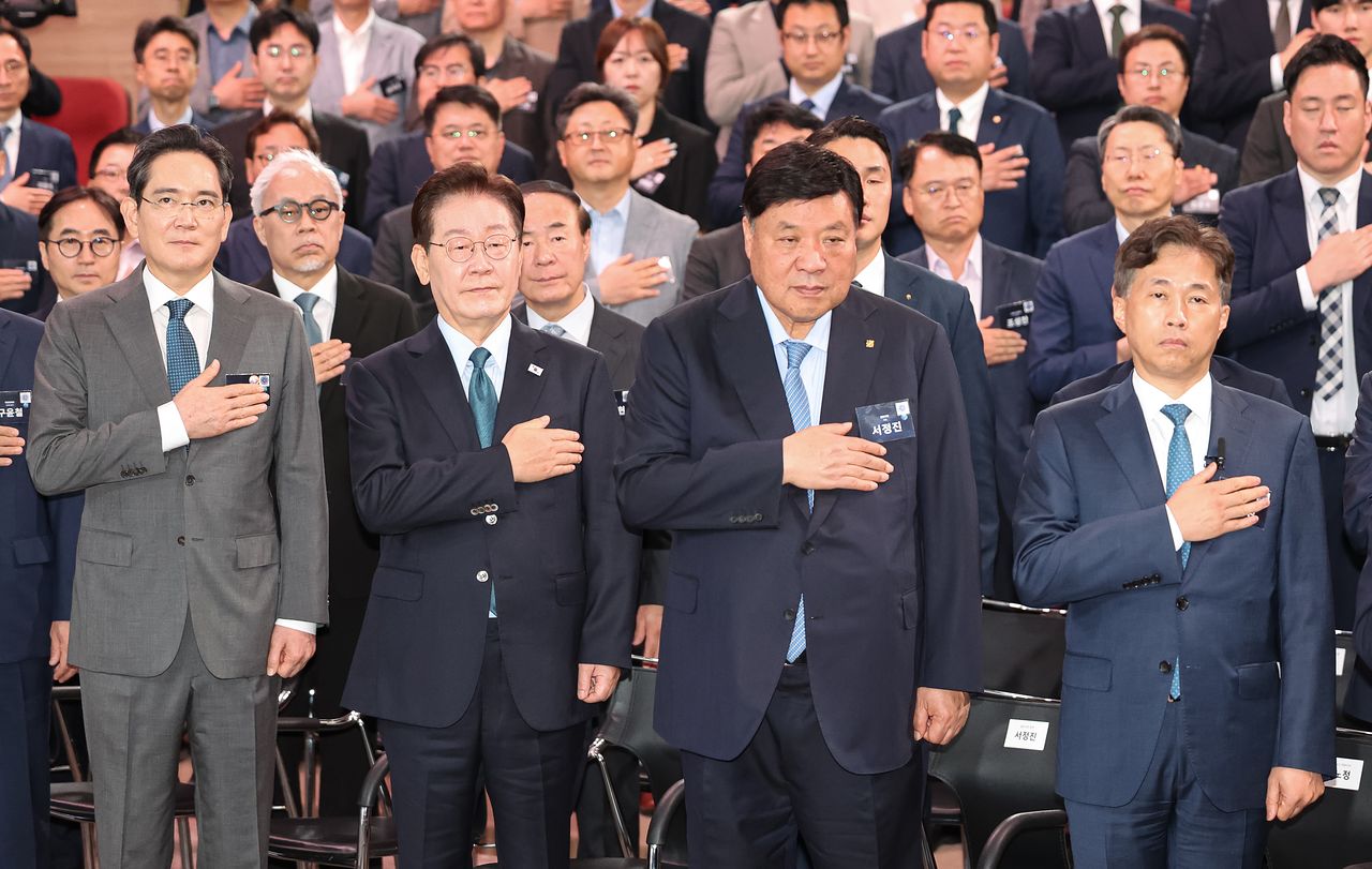 이재명 대통령이 2일 충남 아산시에서 열린 충청권 첨단산업 발전비전 국민보고회에서 국민의례를 하고 있다.   왼쪽부터 이재용 삼성전자 회장, 이재명 대통령, 서정진 셀트리온 회장, 곽노정 SK하이닉스 대표. 연합뉴스
