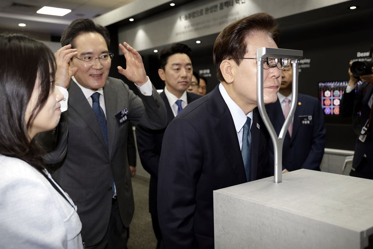 이재명 대통령이 2일 충남 아산에서 열린 충청권 첨단산업 발전비전 국민보고회에서 AR 글라스를 체험하고 있다. 왼쪽은 이재용 삼성전자 회장. 뉴스1