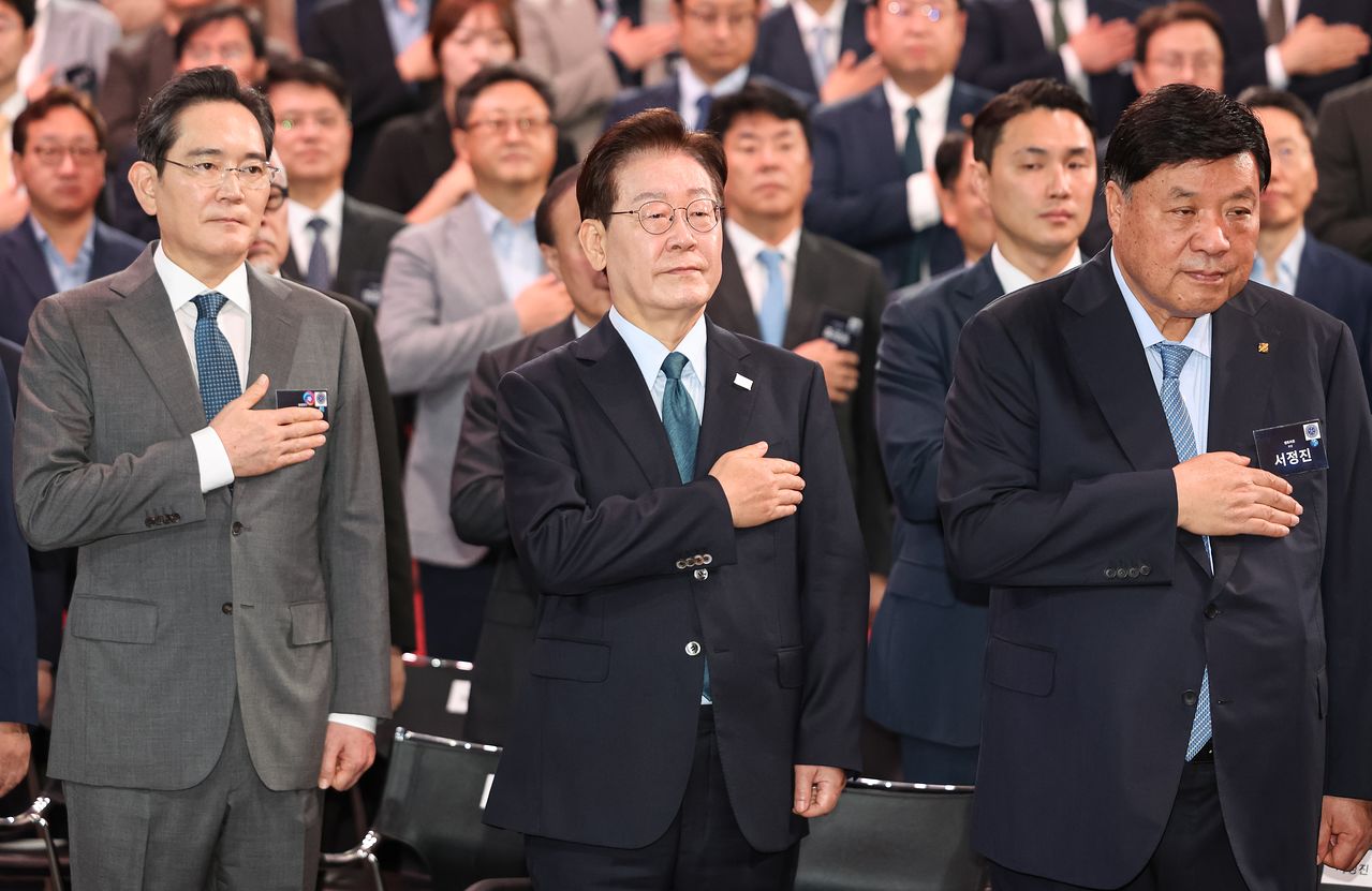 이재명 대통령이 2일 충남 아산시에서 열린 충청권 첨단산업 발전비전 국민보고회에서 국민의례를 하고 있다.   왼쪽부터 이재용 삼성전자 회장, 이재명 대통령, 서정진 셀트리온 회장. 연합뉴스