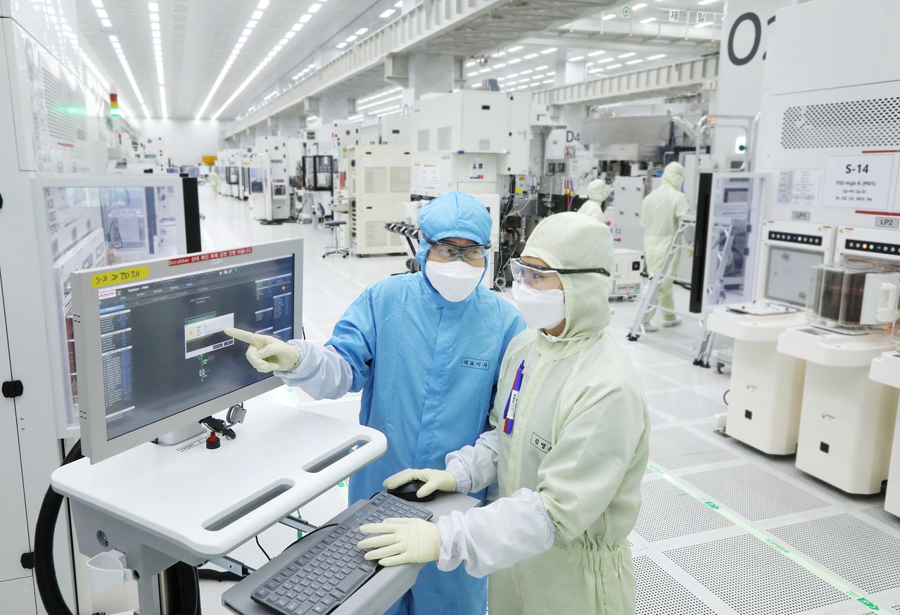 황철주 주성엔지니어링 회장(왼쪽)이 경기도 용인시 기흥구에 있는 연구개발(R&D)센터 내 팹(Fab)에서 엔지니어와 연구·개발 현황을 점검하고 있는 모습. 사진 주성엔지니어링