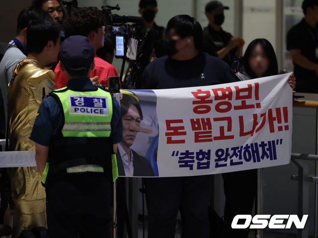 [OSEN=인천공항, 민경훈 기자] 32강 진출에 실패한 대한민국 축구대표팀 중 홍명보 감독을 비롯해 김민재, 황희찬, 설영우, 이강인 등 선수 8명이 30일 새벽  인천국제공항을 통해 귀국했다. 손흥민 등 나머지 선수들은 쪼개져서 각자 귀국한다. 대표팀 귀국 본진은 30일 새벽 인천공항에 도착한다.축구팬들이 '홍명보 나가' 를 외치고 있다. 2026.06.30 / rumi@osen.co.kr