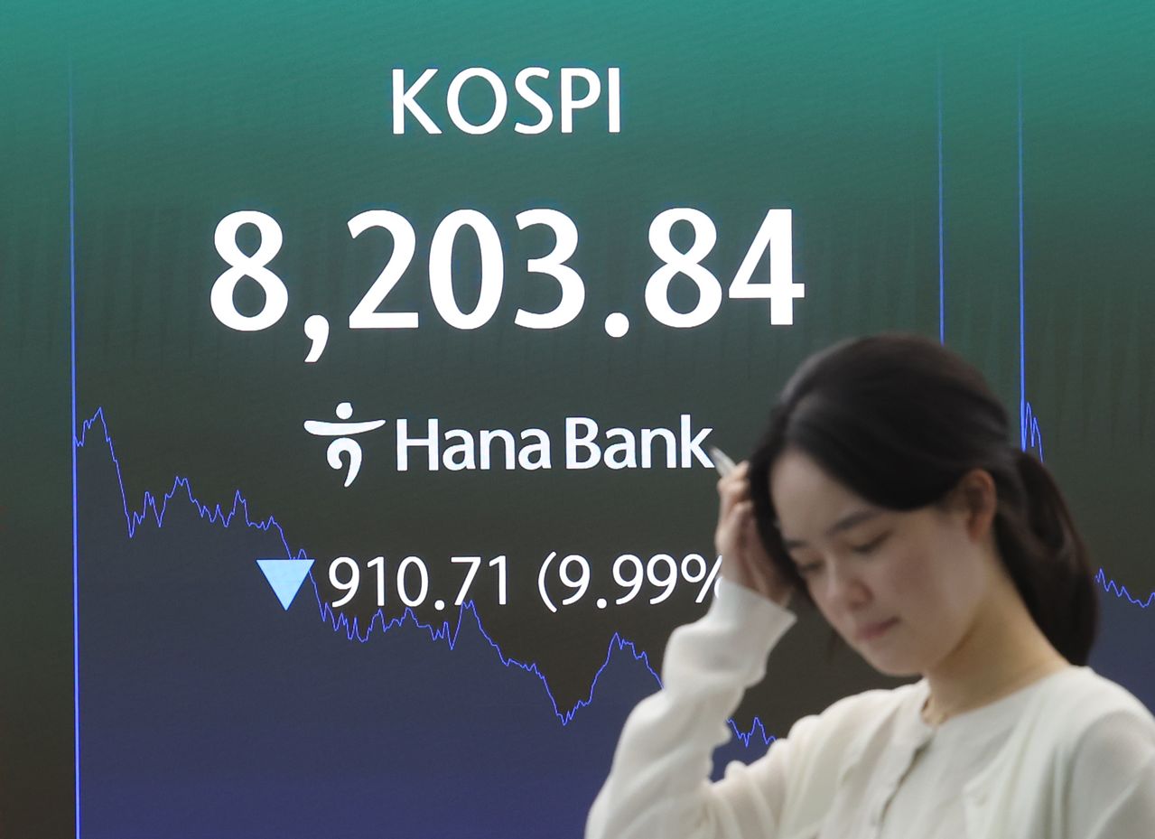 코스피가 10% 가까이 급락해 8,200선을 간신히 지키며 마감한 지난달 23일 서울 중구 하나은행 딜링룸에서 직원이 업무를 보고 있다. 이날 코스피는 전 거래일 대비 910.71포인트(9.99%) 내린 8,203.84로 거래를 마쳤다. 연합뉴스