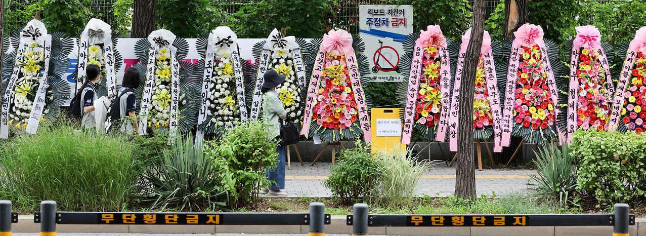 지난달 29일 고교야구 대회 도중 광주일고를 향해 ‘스타벅스 가야지’ 응원 구호를 외쳐 논란을 빚은 배재고 야구부를 비판하는 근조 화환과 과도한 비난 여론에 대해 배재고 학생들을 응원하는 화환이 2일 서울 강동구 배재고등학교 앞에 나란히 놓여 있다. 우상조 기자