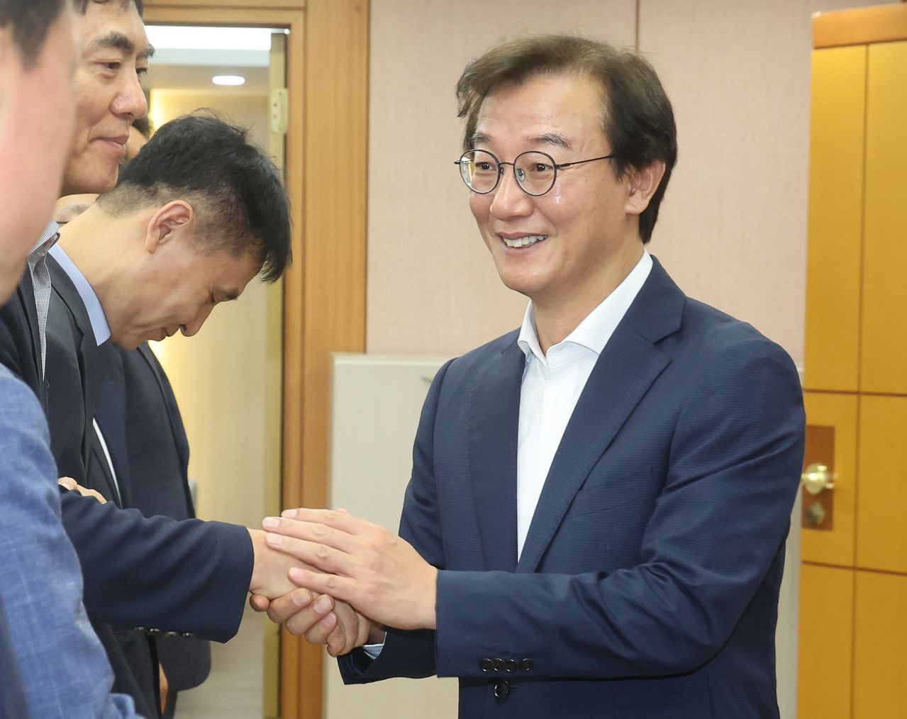 전재수 부산시장이 지난 1일 첫 출근하며 부산시청 집무실 앞에서 대기하고 있던 간부 공무원들과 악수하고 있다. 송봉근 객원기자 
