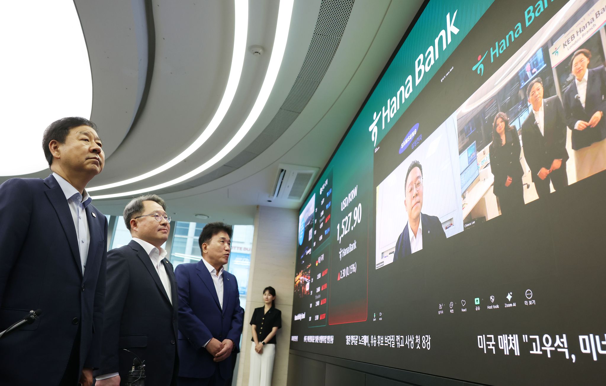 구윤철 경제부총리 겸 재정경제부 장관과 권민수 한국은행 부총재보, 함영주 하나 회장이 6일 오전 서울 중구 하나은행 딜링룸을 방문해 삼성전자 재경팀, 하나은행 런던지점과 화상으로 외환시장 24시간 거래 관련 이야기를 나누고 있다. 