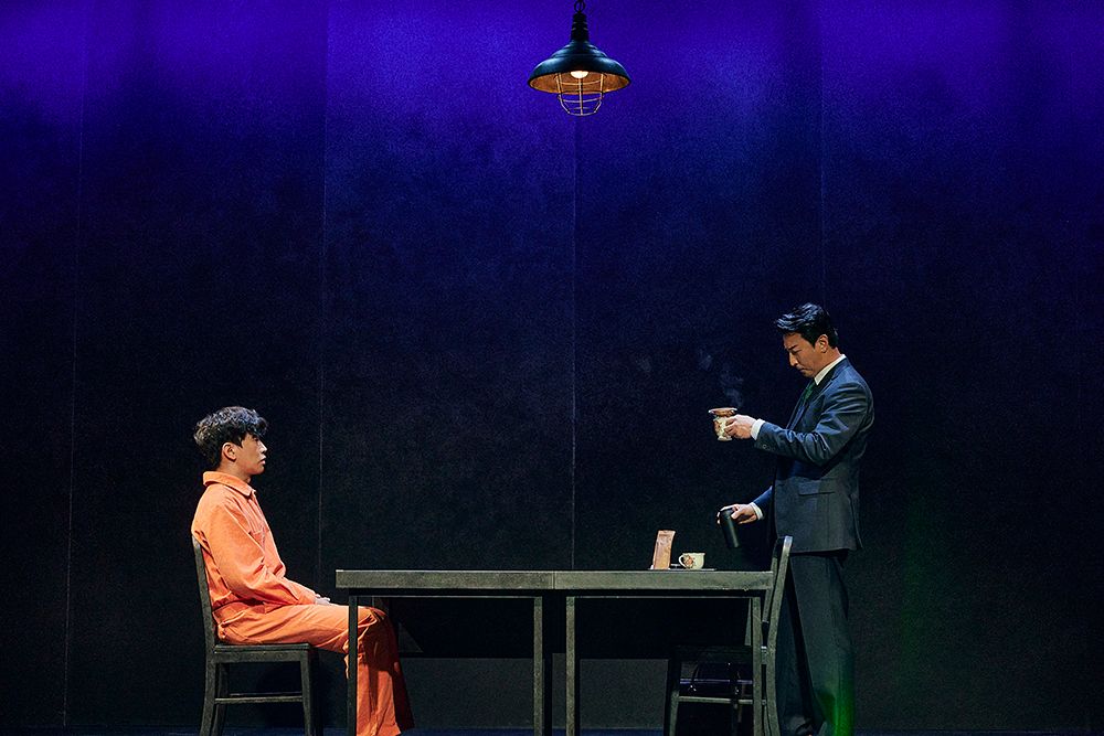 연극 ‘댄포스가 옳았다’에서 천재 프로파일러로 불리는 ‘조너스 보튼’(박건형·오른쪽)이 연쇄 살인범 용의자 ‘존 조우’(고상호)에게 직접 커피를 내려 주며 대화를 이어가고 있다. [사진 파커블앤코]