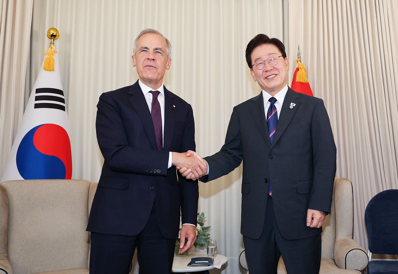 지난 6월 프랑스 G7 정상회의에 참석한 이재명 대통령이 마크 카니 캐나다 총리를 만나 악수하고 있다. 캐나다는 지난 6일 차세대잠수함 도입사업의 우선협상 대상자로 한국이 아닌 같은 나토 회원국인 독일의 티센크루프마린시스템스(TKMS)를 최종 선정했다. [청와대사진기자단]