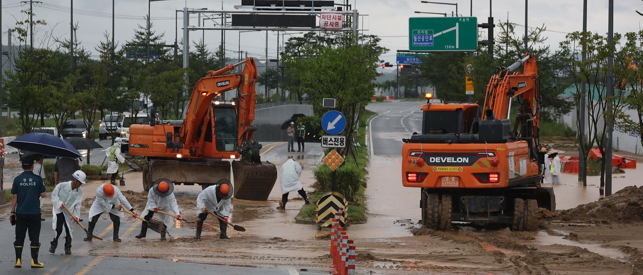 폭우가 내린 9일 세종시 한별동 BRT 교차로 부근 도로가 공사장에서 흘러내린 토사에 덮여 침수되자 작업자들이 복구작업을 벌이고 있다. 연합뉴스                      