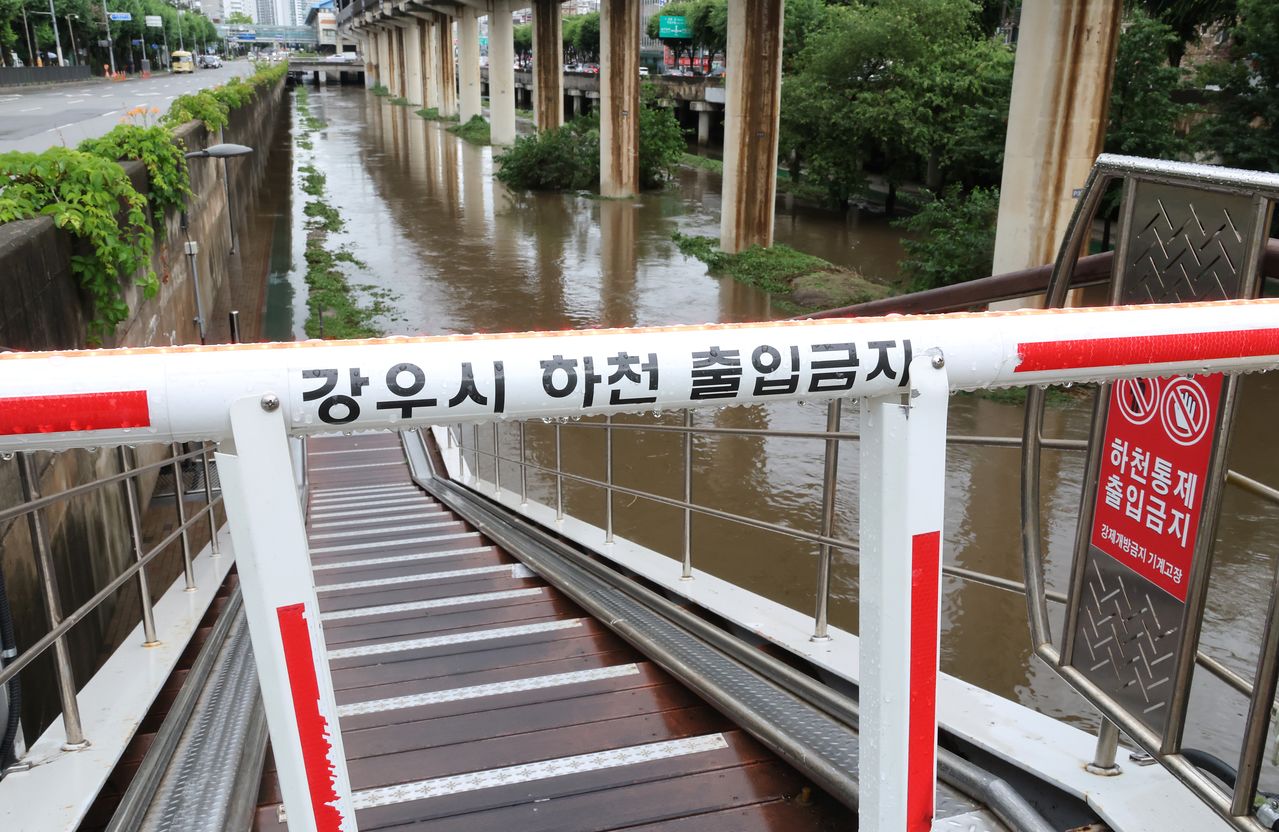 9일 국지성 집중호우로 침수주의보가 발령된 서울 지하철 대림역 인근 도림천 수위가 상승하자 하천 출입을 막는 차단기가 내려와 있다. 연합뉴스
