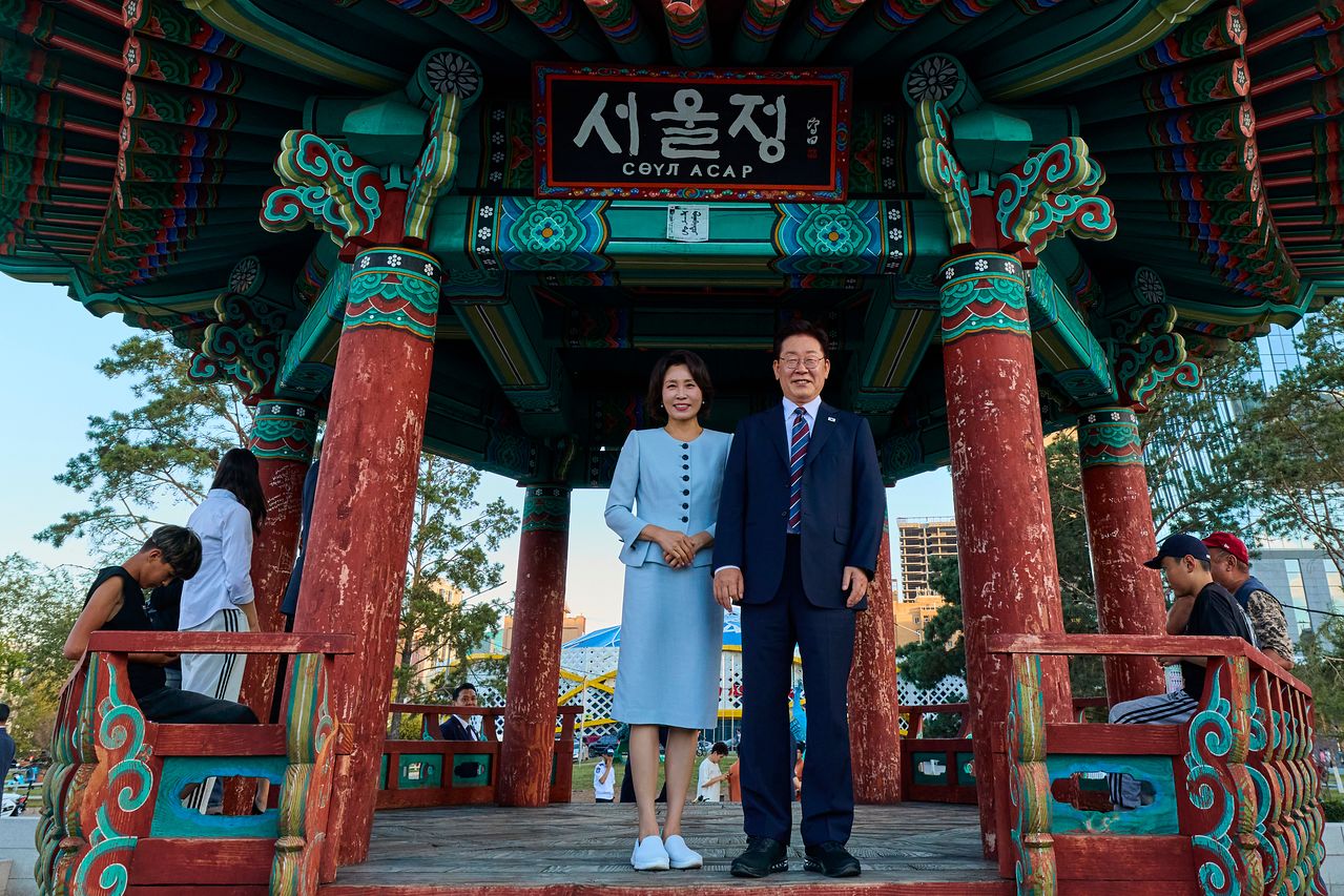 몽골을 국빈 방문 중인 이재명 대통령과 김혜경 여사가 9일(현지시간) 울란바타르 '서울의 거리'에서 기념촬영을 하고 있다.   '서울의 거리'는 1995년 서울-울란바타르 자매결연을 계기로 조성한 것으로, 음식점과 편의점 등 한국 문화를 접할 수 있는 곳이다. 공동취재단