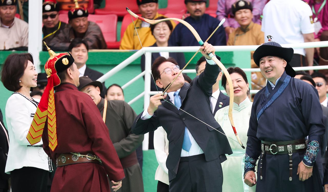 몽골을 국빈 방문 중인 이재명 대통령이 11일(현지시간) 울란바타르 나담축제장에서 전통활쏘기를 체험하고 있다. 오른쪽은 오흐나 후렐수흐 몽골 대통령. 뉴스1