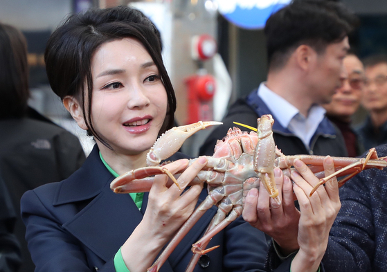 김건희 여사가 포항 죽도시장을 방문해 대게를 들어 보이고 있다. 김 여사의 지방 행사에는 늘 많은 기자가 동행했다. 연합뉴스