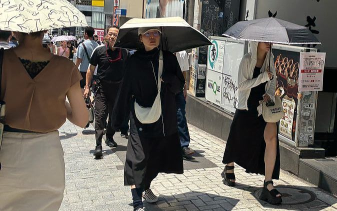 35도가 훌쩍 넘은 15일 도쿄 시부야의 거리에서 한 시민이 UV파카를 입은 채 거리를 걷고 있다. 유성운 기자