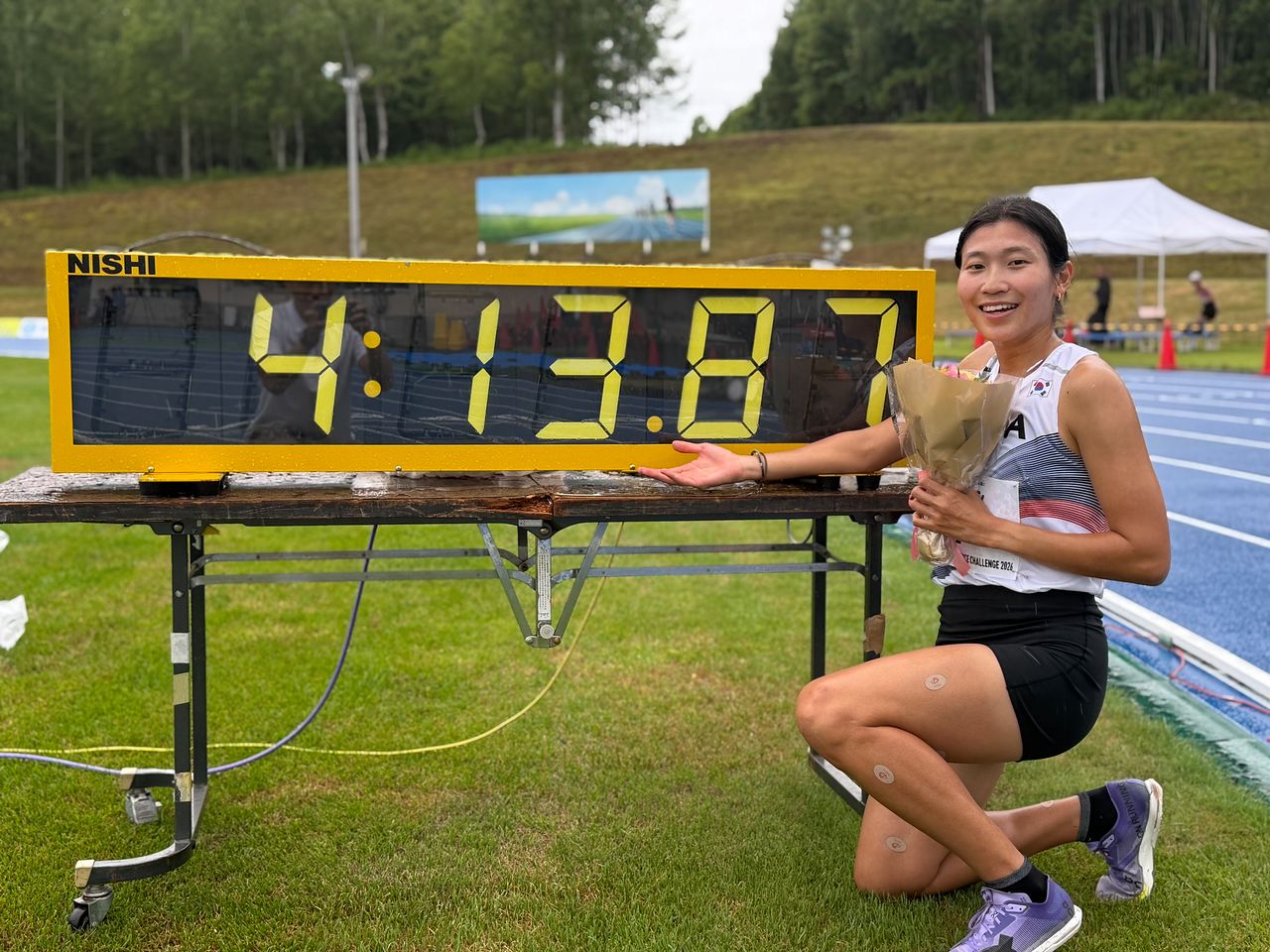 무릎 부상을 극복하고 한국 여자 1500m 기록을 34년 만에 갈아치운 육상 중·장거리 간판 박나연. 타이머에 찍힌 자신의 신기록을 가리키며 활짝 웃고 있다. [사진 대한육상연맹]
