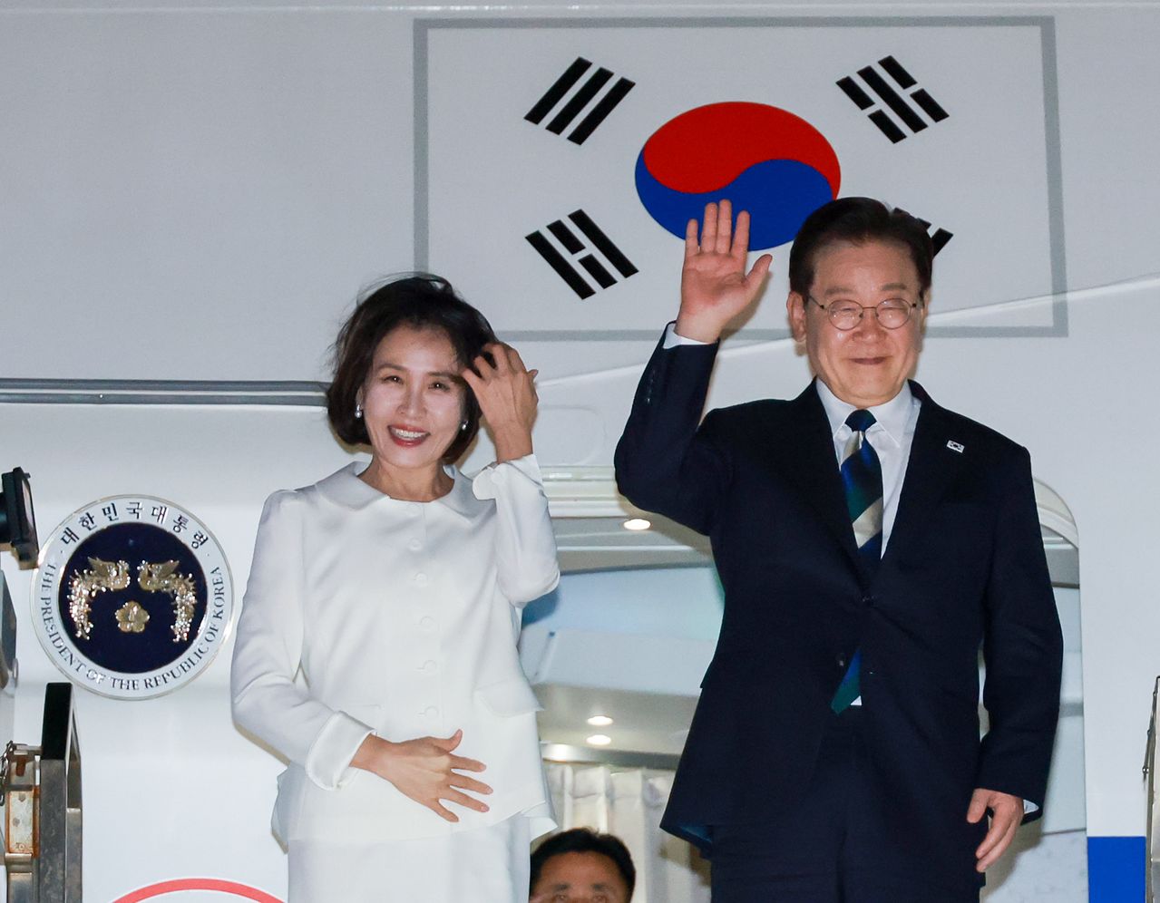 미국 샌프란시스코 방문을 마친 이재명 대통령과 김혜경 여사가 25일(현지시간) 샌프란시스코 국제공항에서 브라질로 향하는 공군 1호기에 탑승하기 전 환송 인사들에게 인사하고 있다. 연합뉴스