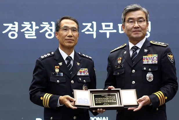 유재성 경찰청장 직무대행이 6월 30일 정년 퇴임한 박성주 전 국가수사본부장에게 재직기념패를 전달하고 있다. [연합뉴스]