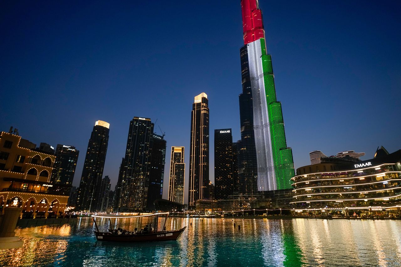 지난 5월 6일(현지시간) 아랍에미리트(UAE) 두바이에서 관광객을 태운 소형 보트가 두바이 분수(Dubai Fountain) 쇼를 관람하고 있다. 뒤로 UAE 국기 색으로 점등된 세계 최고층 빌딩 부르즈 할리파가 보인다. AP=연합뉴스