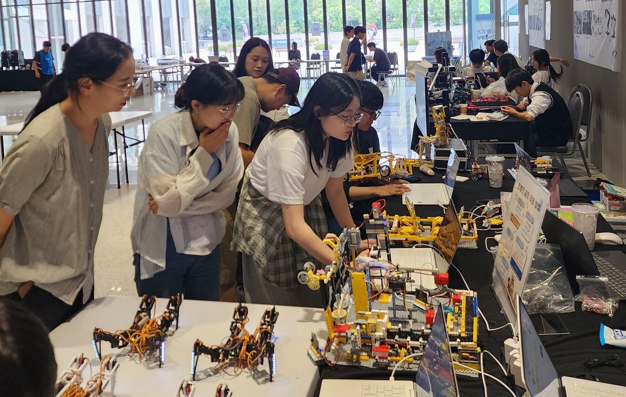 지난달 17일 숙명여대에서 열린 서울시교육청의 사제동행 AI·로봇캠프에 참가한 학생들과 교사들이 AI 레고 로봇 부스를 살펴보고 있다. 성원경 상암고 교사