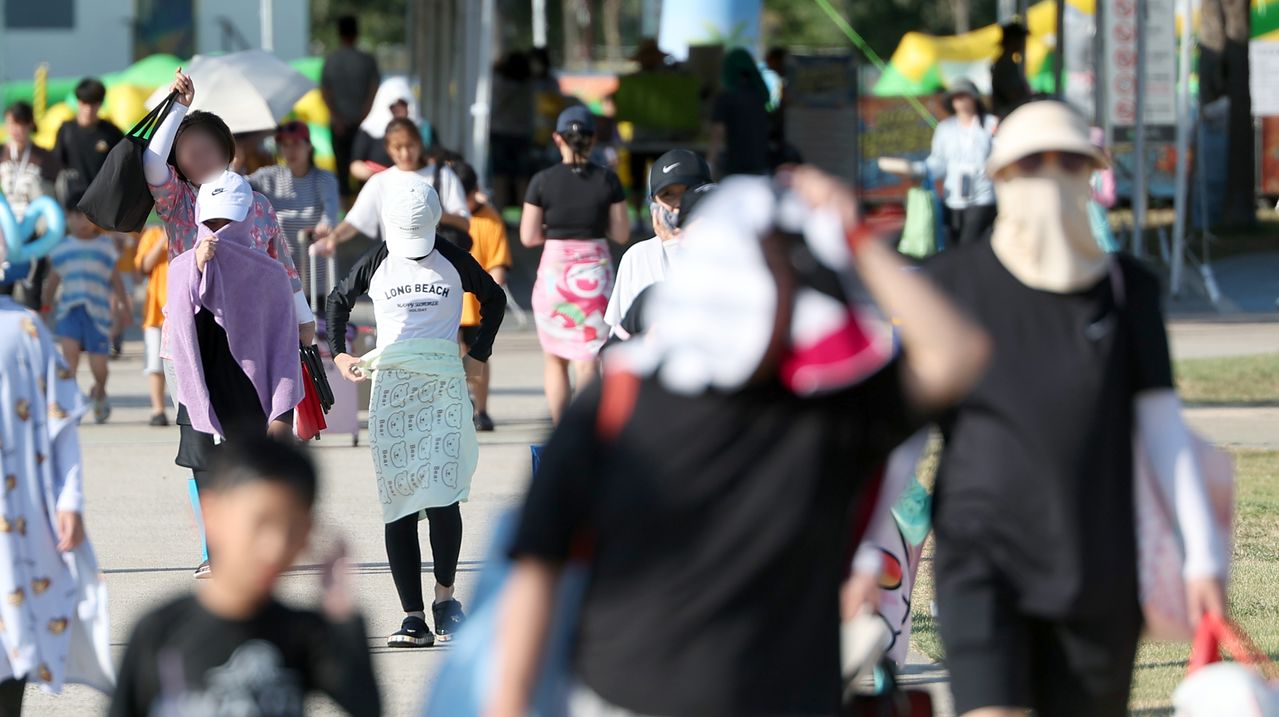  경남 양산지역 낮 최고기온이 40.3도까지 치솟은 지난달 29일 오후 양산시 물금읍 운영이 종료된 황산공원 물놀이장을 나서는 피서객들이 모자와 양산으로 뜨거운 햇빛을 가리고 있다. 연합뉴스